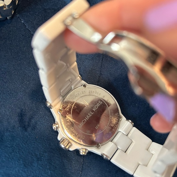 Michael Kors woman’s white crystal bezel watch.